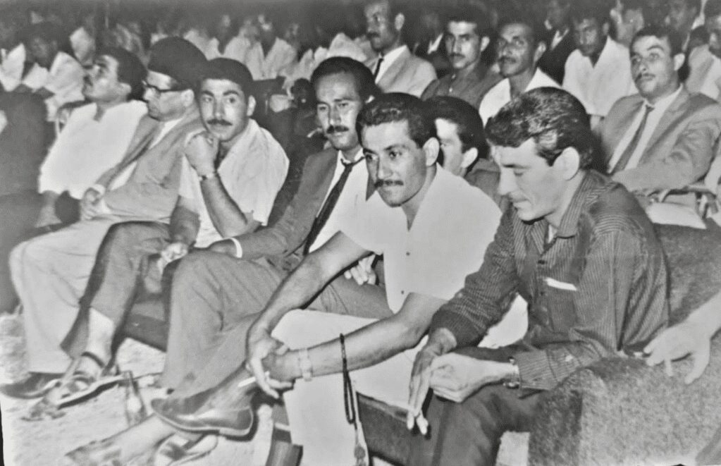 من اليمين، الشعراء: كاظم الرويعي، يوسف البصري، عزيز السماوي، نزار القريشي، محمد عزيز كاندو، وخلف الرويعي يجلس الشاعر ناجي منجي. المصدر: أرشيف الكاتب 